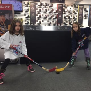 Two Children Posing With Hockey Stick At New York Rangers Learn To Play Event
