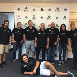Pure Hockey Learn To Play Event Staff Posing For Picture In Front of Pure Hockey Logo Backdrop