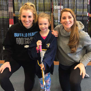 Two Women and One Child Posing at Buffalo Sabres Learn To Play Event
