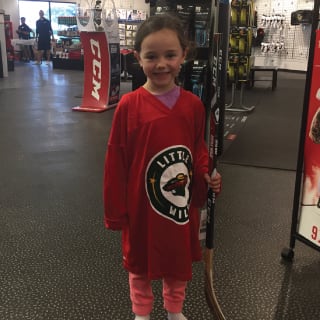 Child Posing with Hockey Stick At Minnesota Wild Learn To Play Event