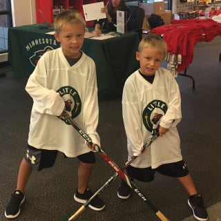 Two Children Posing with Hockey Sticks At Minnesota Wild Learn To Play Event
