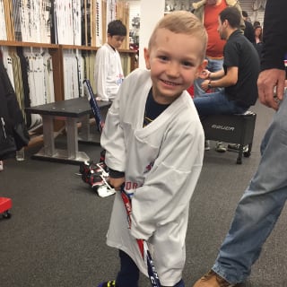 Child Posing with Hockey Stick At Minnesota Wild Learn To Play Event