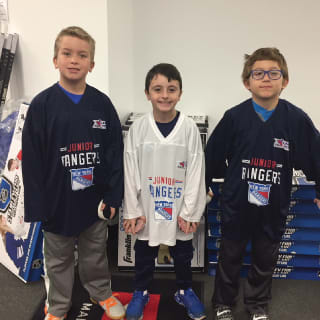 Three Children Posing with Hockey Stick At New York Rangers Learn To Play Event