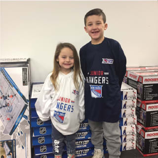 Two Children Posing with Hockey Stick At New York Rangers Learn To Play Event