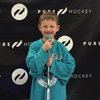 Young Kid In San Jose Sharks Learn To Play Jerseys Holidng Hockey Sticks And Smiling At Camera